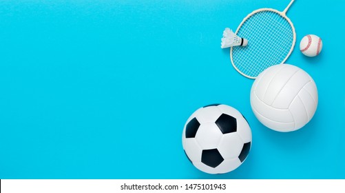 Assorted sports equipment including a soccer ball, volleyball, baseball, badminton racket on a light blue background