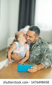 Reuniting at home. Happy father and daughter reuniting at home and watching cartoons together
