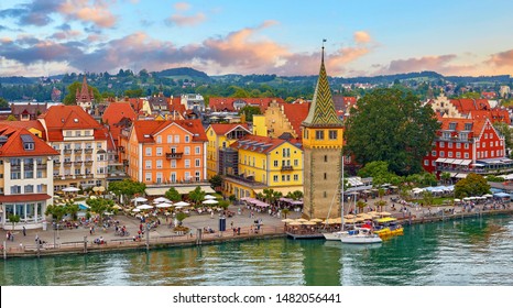 Lindau, Germany. Antique Bavarian town in Bavaria at coastline of Lake Constance (Bodensee). Habour along embankment with traditional houses and tower. Sunset evening landscape.