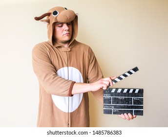 黒いカチンコを持つコスプレ衣装の男。映画を作る面白い動物パジャマ パジャマの男。アマチュアシネマ映画の監督・演出。創造的なコンセプト。日本のアニメ。