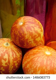 Vertikale Nahaufnahme der gestreiften, orangefarbenen Früchte der 'Tigger'-Melone, einer Erbstücksorte, die sowohl essbar als auch duftend ist, mit Kopierraum