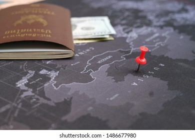 El pasaporte y el dólar estadounidense en el mapa mundial se centran en Rusia con un alfiler rojo con fondo negro.