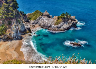 Voda z McWay Falls padá na pláž v McWay Cove v Big Sur v Kalifornii.