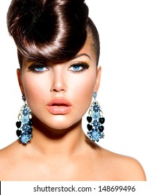 Retrato de niña modelo de moda con ojos azules y aretes. Peinado creativo. Peinado. Maquillaje. Mujer de belleza aislada sobre un fondo blanco