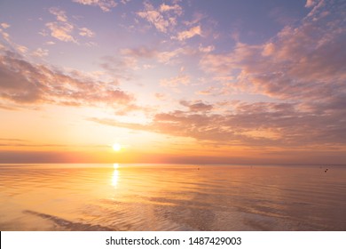 Ruhiges Meer mit Sonnenuntergangshimmel und Sonne durch die Wolken vorbei. Meditationsozean und Himmelhintergrund. Ruhige Seelandschaft. Horizont über dem Wasser.