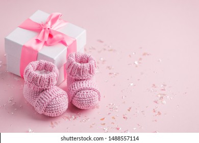 暖かいメッセージ、ベビー シャワー、最初の新生児パーティーの背景、コピー スペースのコピー スペースとピンクの背景に小さなベビー ソックスとギフト ボックスのペア