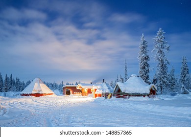Paisaje invernal con cabaña de cabaña por la noche en Kiruna Suecia Laponia por la noche con rastro de estrellas