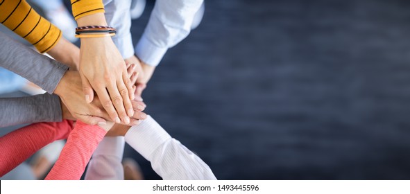 Schließen Sie herauf Draufsicht der jungen Geschäftsleute, die ihre Hände zusammenstellen. Stapel Hände. Einheits- und Teamwork-Konzept.