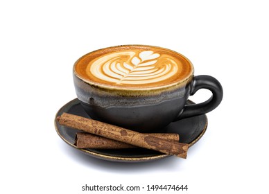Tampilan samping kopi latte panas dengan seni latte dan batang kayu manis dalam cangkir dan piring hitam matt vintage yang diisolasi pada latar belakang putih dengan jalur kliping di dalamnya. Teknik menumpuk gambar.