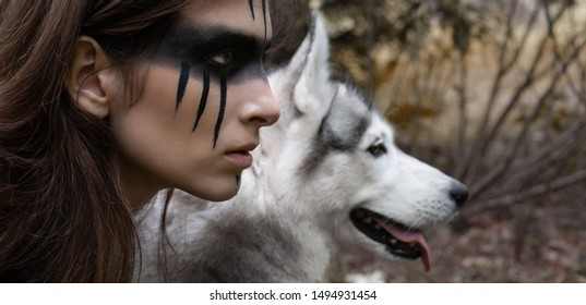 オオカミの顔を背景に彼女の頬にウォー ペイントを持つ女性ハンターのクローズ アップの肖像画