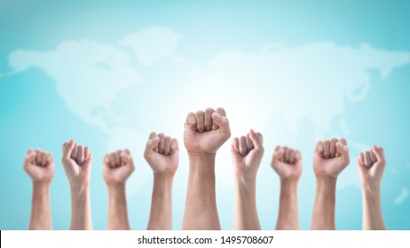 世界地図と空の背景に分離された人々 の握りこぶし (男性と女性) の手で国際人権または労働者の日