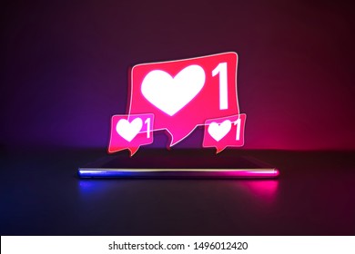 Smartphone with love social symbol neon logo. Blue and pink light copy space background . Futuristic data community cyberpunk concept.