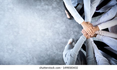 Schließen Sie herauf Draufsicht der jungen Geschäftsleute, die ihre Hände zusammenstellen. Stapel Hände. Einheits- und Teamwork-Konzept.