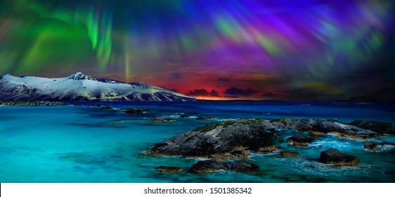 Wunderschöner, unwirklich schöner Nachtblick auf die Reflexion der Nordlichter im Wasser des Ozeans und der schneebedeckten Berge. Nächtliche Nordlichter sind einfach ein erstaunlicher Anblick.