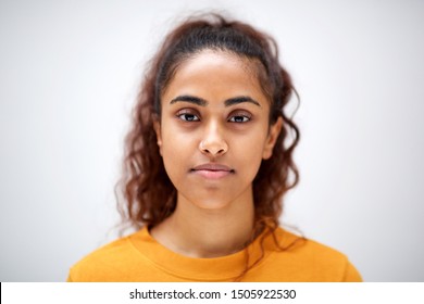 Close up horizontal front portrait of attractive young indian woman with serious expression on face