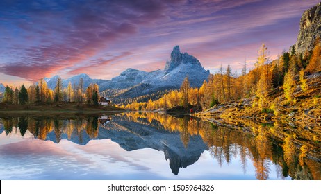 herfst uitzicht op Lake Federa in de Dolomieten bij zonsondergang. Fantastische herfstscène met kleurenhemel, majestueuze rotsachtige berg en kleurrijke bomen die zonlicht in de Dolomieten gloeien. Locatie: Federa-meer met Dolomiet