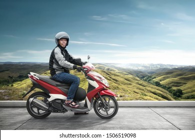 Asian motorcycle taxi man with his motorcycle on the asphalt road