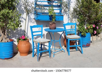 Leuchtend blaue Holzstühle im griechischen Dorf Adele auf Kreta