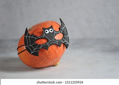 Pumpkin in batman's mask. Halloween holiday attribute. Close-up. Free space for text. Grey background.