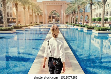 Disfrutando de viajar en los Emiratos Árabes Unidos. Mujer joven con cámara caminando por el centro de Dubai.