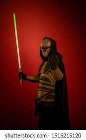 Schauspieler ein Mann in einer Maske und in Kostümen von fiktiven Fantasy-Figuren, die auf einem roten Hintergrund posieren