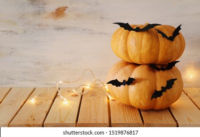 vakantie Halloween afbeelding. pompoenen en vleermuizen over houten witte tafel