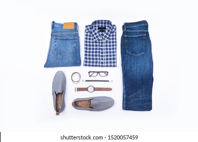 Top view of folded long sleeve plaid shirt and gray casual shoes ,sunglasses ,blue jeans ,belt  on white background
