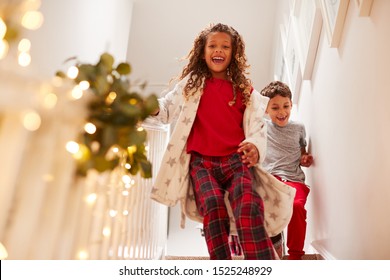 Aufgeregte Kinder rennen die Treppe hinunter, um am Weihnachtsmorgen Geschenke zu öffnen