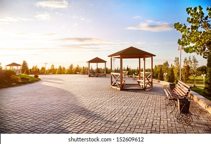 Summer houses with benches at sunset sky background in dendra park of first president Nursultan Nazarbayev in Almaty, Kazakhstan