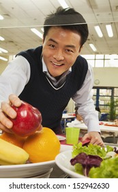 学校の食堂で健康食品に手を伸ばす教師