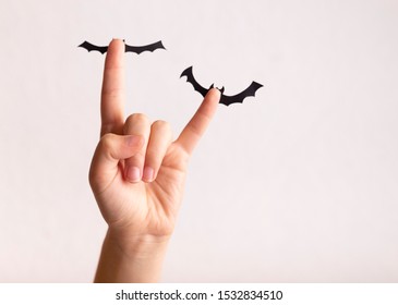 Concepto de Halloween. Mano de mujer sosteniendo murciélagos de papel sobre fondo blanco, espacio de copia