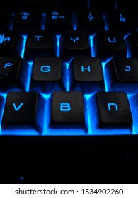 Bàn phím chơi game có đèn nền RGB màu xanh điện tử trong bóng tối