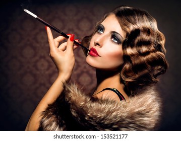 Retro Frauenporträt. Schöne Frau mit Mundstück. Zigarette. Rauchende Dame. Vintage gestyltes Schwarzweiss-Foto. Altmodisches Make-up und Fingerwellenfrisur. Stil der 20er oder 30er Jahre.