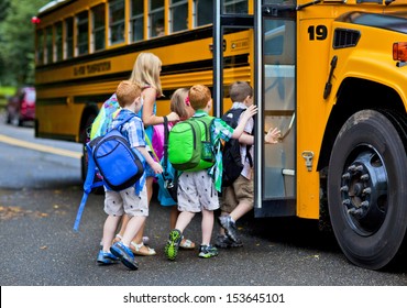 Eine Gruppe kleiner Kinder steigt in den Schulbus ein