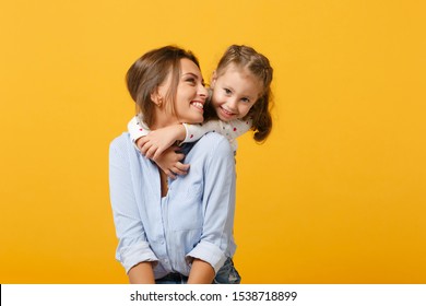 Woman in light clothes have fun with cute child baby girl 4-5 years old. Mommy little kid daughter isolated on yellow background studio portrait. Mother's Day love family parenthood childhood concept