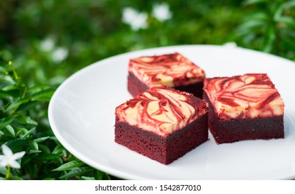 白い皿にのせたレッドベルベットクリームチーズブラウニー