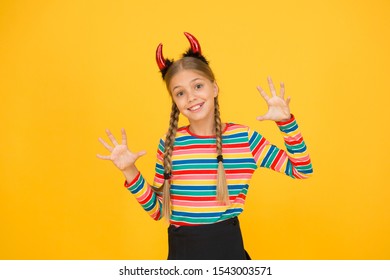 Zij duivel. Halloween-partijmeisje gele achtergrond. Het meisje draagt een hoofdband van rode duivelshoorns. Mysterieus meisje met Halloween-look. Klein meisje veranderde in een boze demon.