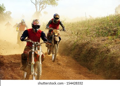 Motorcyclist on the competition at motorcycle race . The motorcycle race hole on December at Dambri waterfall, motorcyclist try to speed up goal, red soil way, indistinct dust