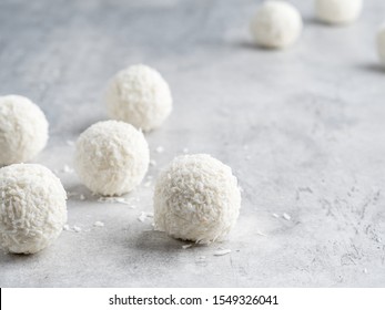 Bolas de coco cubiertas de copos de coco sobre fondo gris blanco