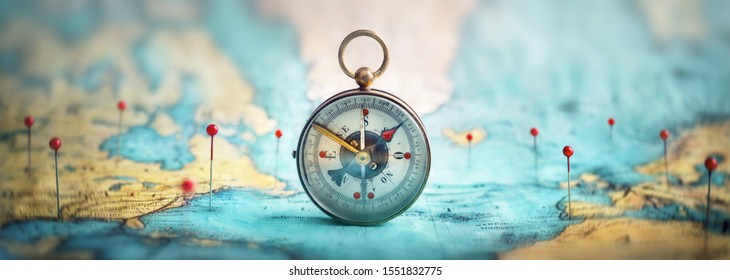 Magnetkompass und Ortsmarkierung mit einem Stift auf Routen auf der Weltkarte. Abenteuer, Entdeckung, Navigation, Kommunikation, Logistik, Geographie, Transport und Reisethema Konzept Hintergrund.