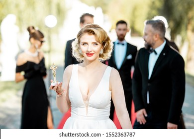Potret seorang wanita cantik berpakaian gaya retro sebagai aktris film terkenal di karpet merah selama upacara penghargaan di luar ruangan