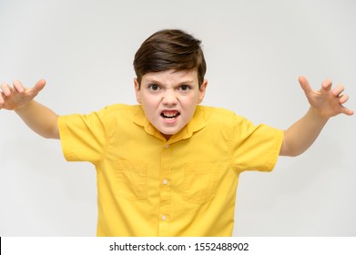 Concept boy teenager shows imitates the behavior of heroes from different movies. Portrait of a child on a white background in a yellow shirt. Standing in front of the camera in poses with emotions.