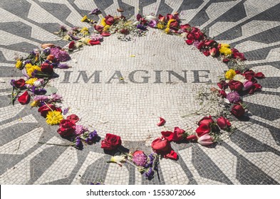ファンや観光客が残した色とりどりの花に囲まれた、ニューヨークのセントラルパークにあるジョン・レノンの記念碑の風景。想像してみてください。