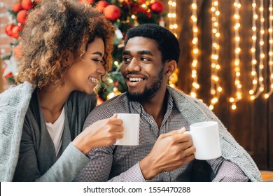Glückliches junges schwarzes Paar, das Kaffee trinkt und den Weihnachtsmorgen zusammen genießt, Kopienraum