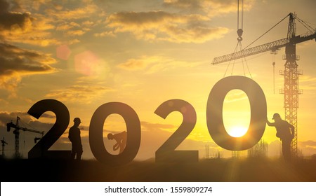 Silhouet van ingenieur en bouwteam werken constructief om te creëren. enorme cijfers 2020 op de bouwplaats, Concept Gelukkig nieuwjaar volgend goed jaar.