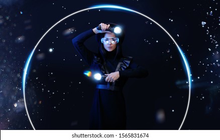 Schöne Frau im futuristischen Kleid über dunklem magischem Hintergrund. Spielermädchen in Gläsern der virtuellen Realität mit Controllern in den Händen. Augmented Reality, Spiel, Hobbykonzept. VR. Blaues Neonlicht.