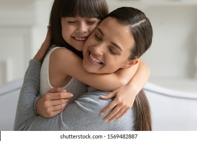 Close-up beeld gelukkige prachtige jonge moeder sterke knuffel kleine openhartige dochter, concept van geadopteerd kind en nieuwe mama, verbinding en toewijding van moeder en klein kind, oprechte gevoelens, liefde en streling
