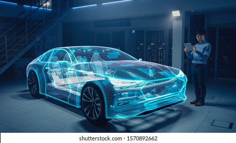 Automotive Engineer werkt aan het chassisplatform voor elektrische auto's, met behulp van tabletcomputer met Augmented Reality 3D-software. Futuristische atomaire faciliteit: virtueel ontwerp met toepassing van gemengde technologie.