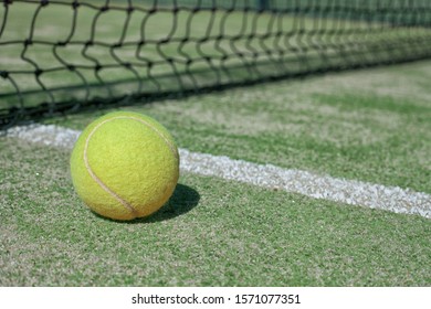 Pelota de tenis en una cancha de tenis al lado de la línea lateral