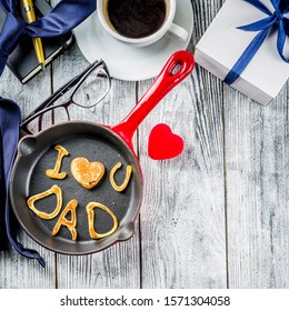 Father's day holiday concept, greeting card background with presents and pancakes letter inscription For best father, I love you dad, wooden background copy space top view
